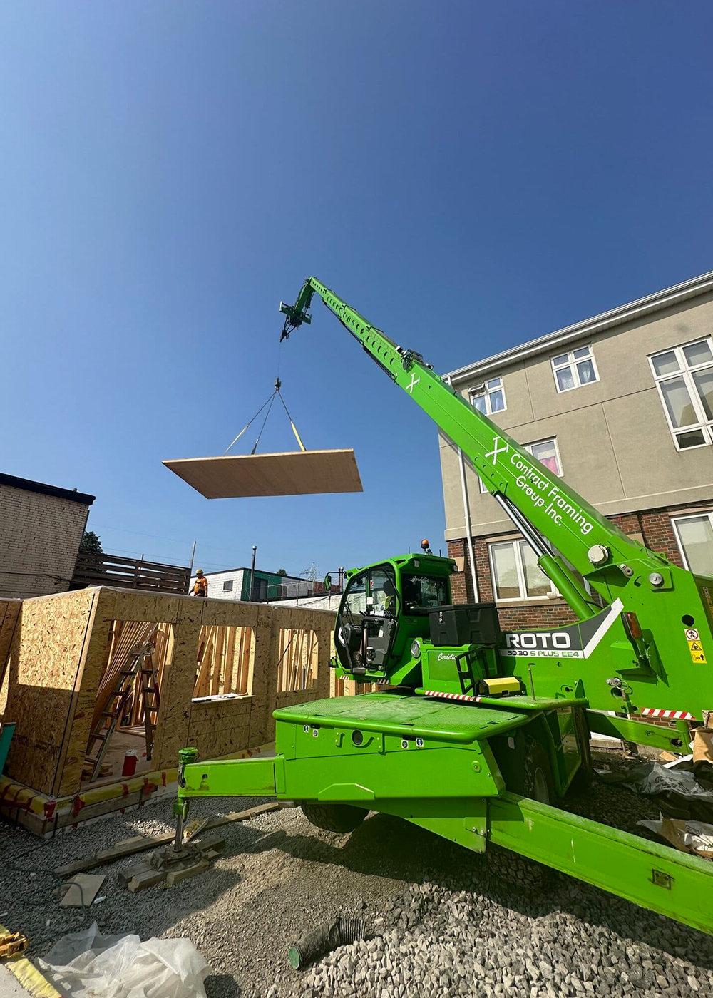 Crane lifting a prefabricated timber panel into place