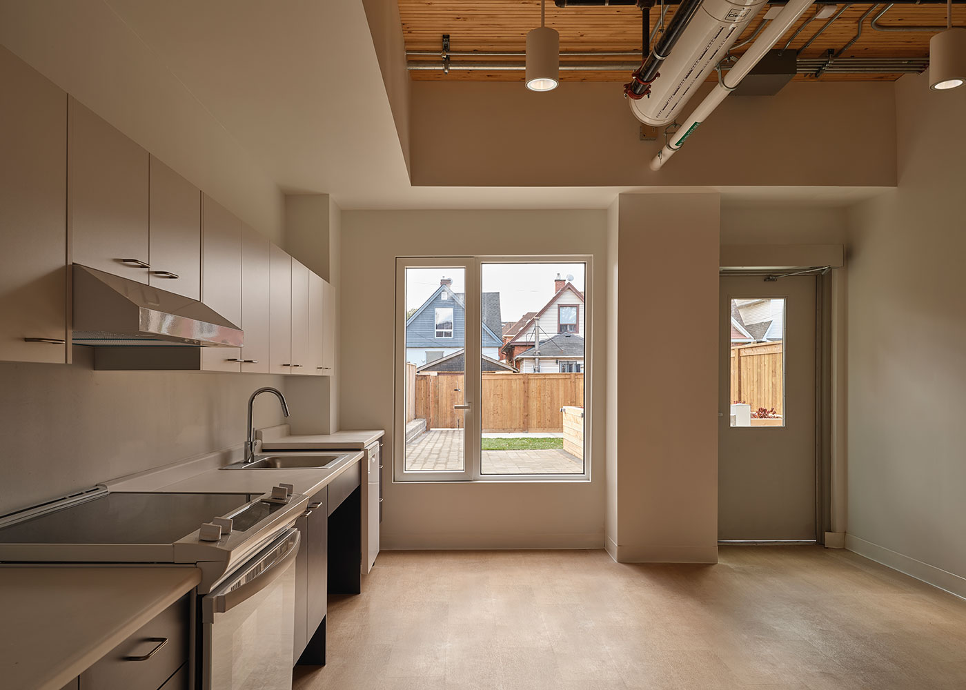 Ground-floor kitchen and support space with exposed building services