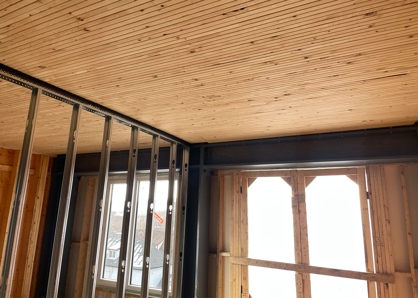 Steel bracing beneath the exposed timber ceiling during construction